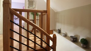 A wooden staircase with a handrail, leading to a landing with a view of a room. - Charming house with garden, high speed, near Bagnoles de l'Orne (Antoigny)