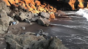 A rocky beach with large boulders and waves crashing onto the shore. - Make It Happen Farm (Velas)