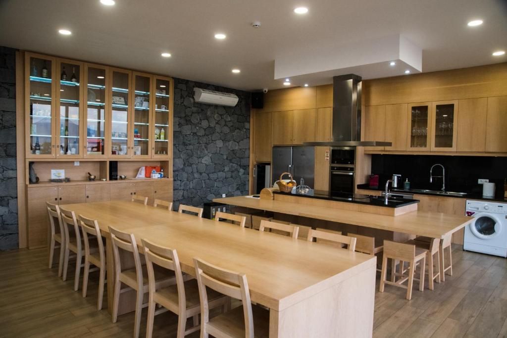 A modern kitchen with wooden cabinets, a central island, and built-in appliances.