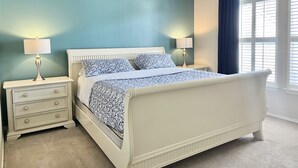 Una camera da letto con un letto, comodini, una cassettiera e una finestra con tende.