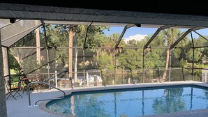 Piscina interior con vista a un lago y árboles.