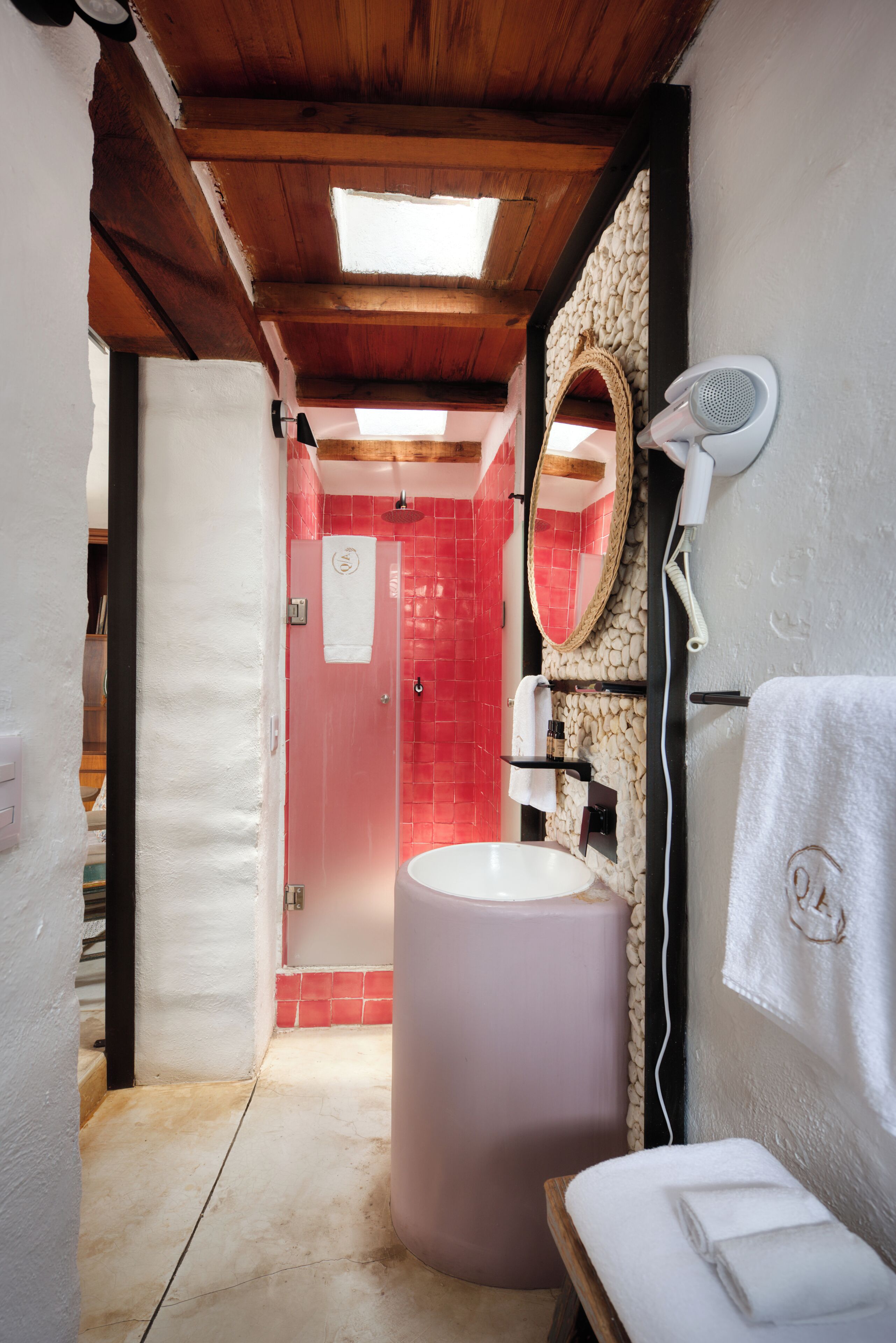A bathroom with a large sink, a mirror, and a shower.