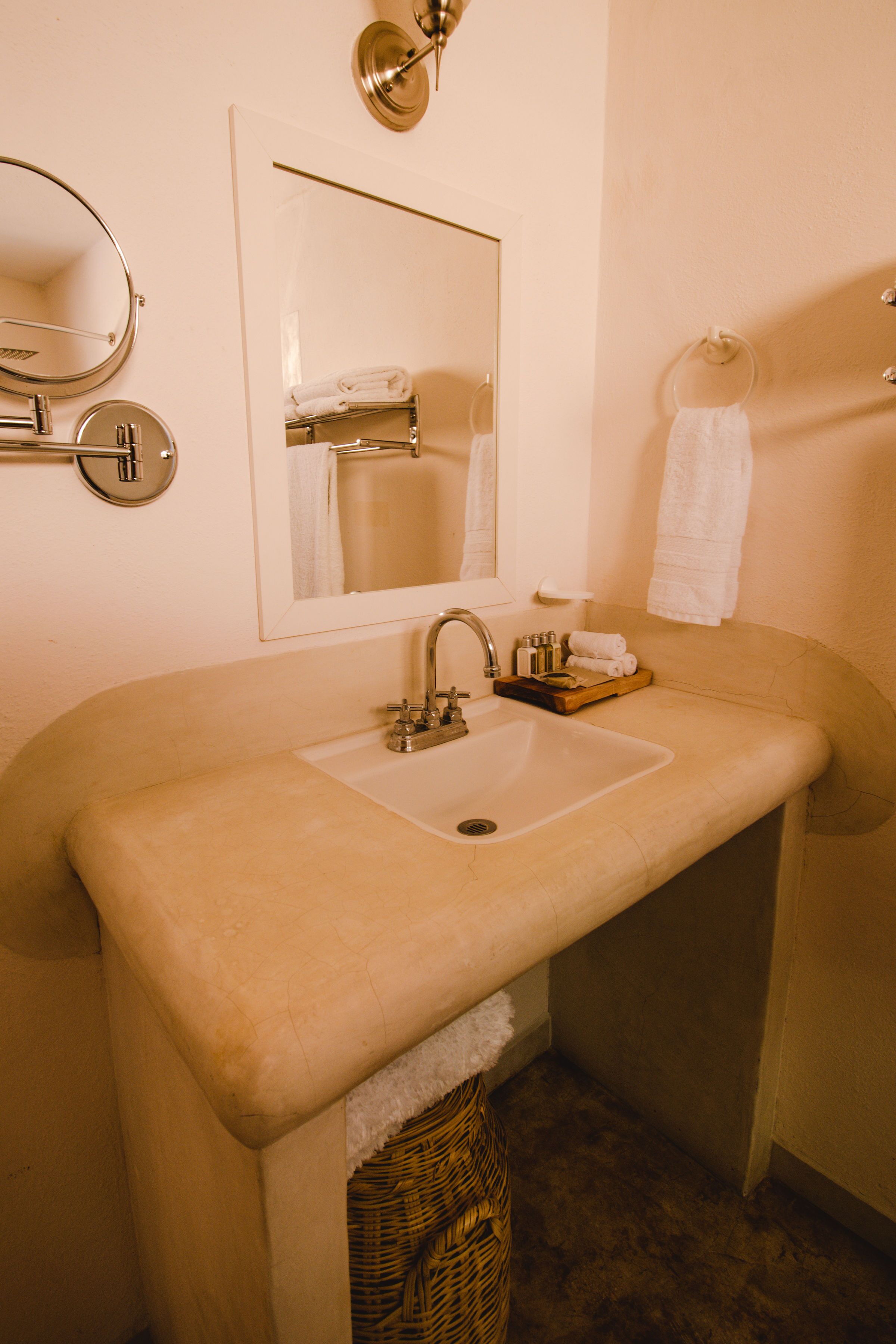 A bathroom with a large sink, a mirror, and a towel rack.