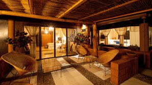 A cozy indoor seating area with wicker chairs and a brick accent wall. - Quinta Ascension - Adults Only (Malinalco)