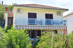 A two-story house with a balcony, air conditioning units, and a tiled roof. - Peaceful location, walk everywhere + parking free (Hvar)