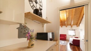 Una cocina moderna con encimera de madera, un reloj y un florero con flores.