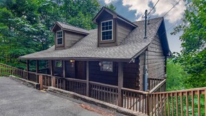 A wooden cabin with a porch and a small staircase leading to a second floor. - Smoky Mountain Top Cabin, New Hot Tub, 10 mins to Gatlinburg or Pigeon Forge (Sevierville)
