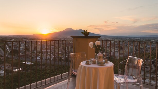 Una mesa para dos con vistas a un paisaje urbano y una montaña al fondo.