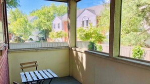 A covered porch with a wooden table and bench, a view of neighboring houses, and a white fence. - Unit2 GR8 LOCATION mins to Longwood Medical Area, BC, BU, HarvMedSchool SPACIOUS (Brookline)