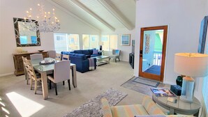 A spacious living area with a dining table, blue sofa, and a chandelier. - Luv Oceanside-1 House to Beach (San Diego)