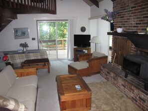 A cozy living room with a fireplace, a television, and a dining area with a table and chairs.