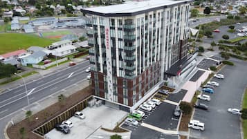 Un bâtiment moderne, reconnaissable à son grand panneau « Ramada », entouré d’un parking et bordé par une route.