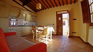 Una cocina acogedora con comedor, vigas de madera en el techo y vistas al exterior.