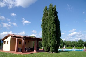 Un bâtiment doté d’un toit en tuiles et d’un patio couvert.