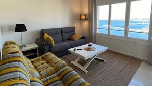 A modern living room with a sofa, a coffee table, and a lamp. - Lovely flat with views Roses Av 48 (Rosas / Roses)
