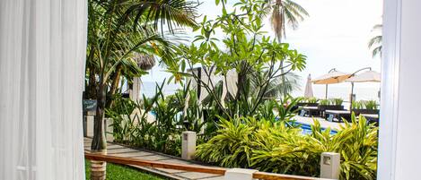 A view of a pool area with palm trees and lounge chairs.