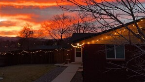 A residential area with a house featuring a small porch and string lights.