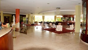 A spacious lobby with a reception desk, multiple seating areas, and a bar. - Ecologic Ville Caldas Vip (Caldas Novas)