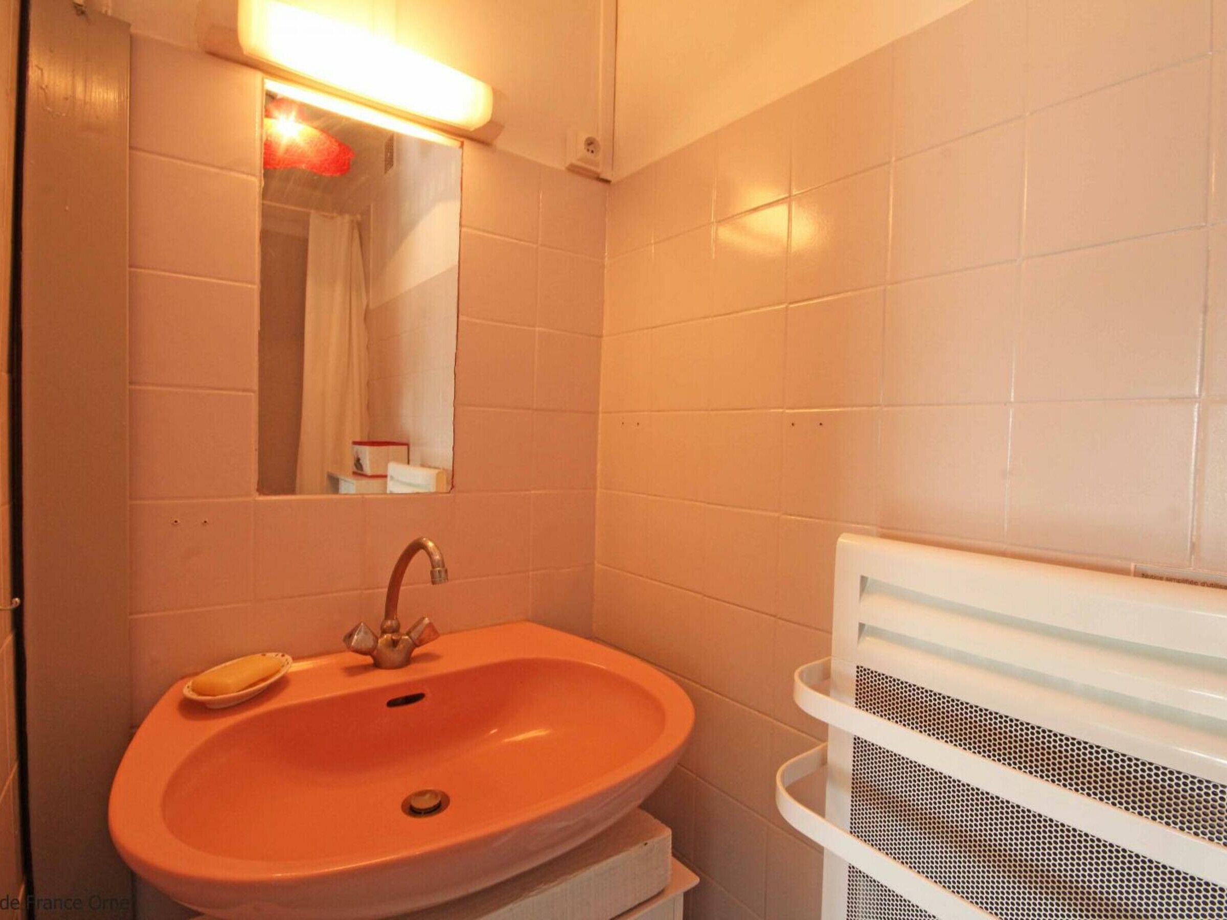 A bathroom with a sink, mirror, and a white towel rack.