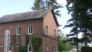 Un bâtiment en briques sur lequel on peut lire l’inscription : « Que la paix règne sur la Terre. »