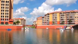 Un hôtel situé au bord de l’eau, composé de plusieurs bâtiments, donnant sur une étendue d’eau calme, et où l’on peut voir des bateaux.