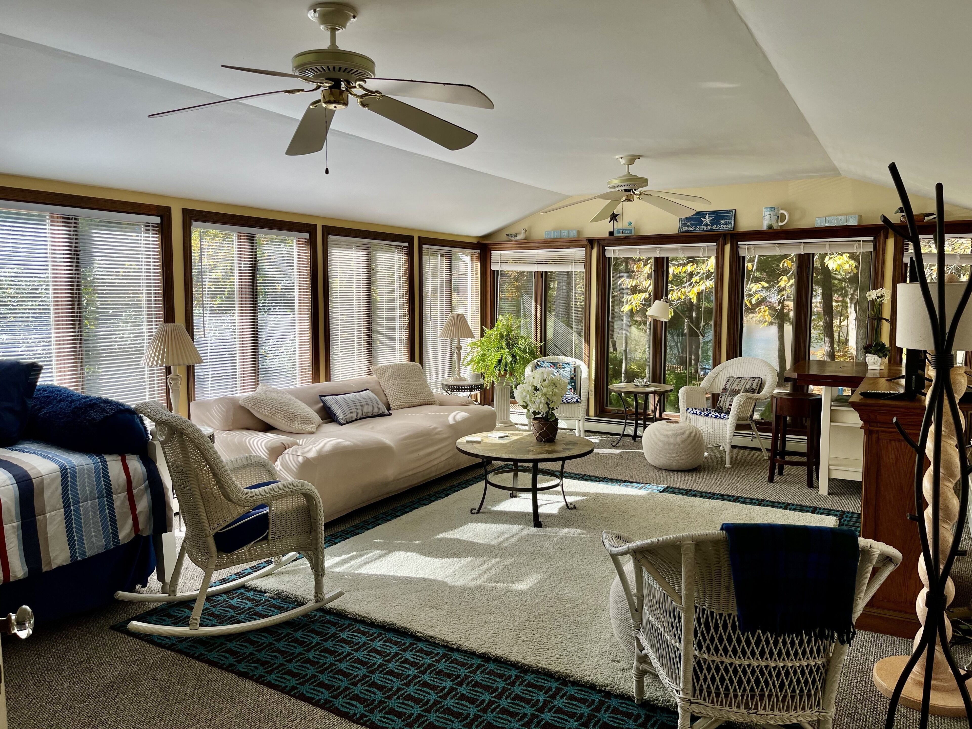 A spacious living room with a sofa, rocking chair, and a dining area with a table and chairs.