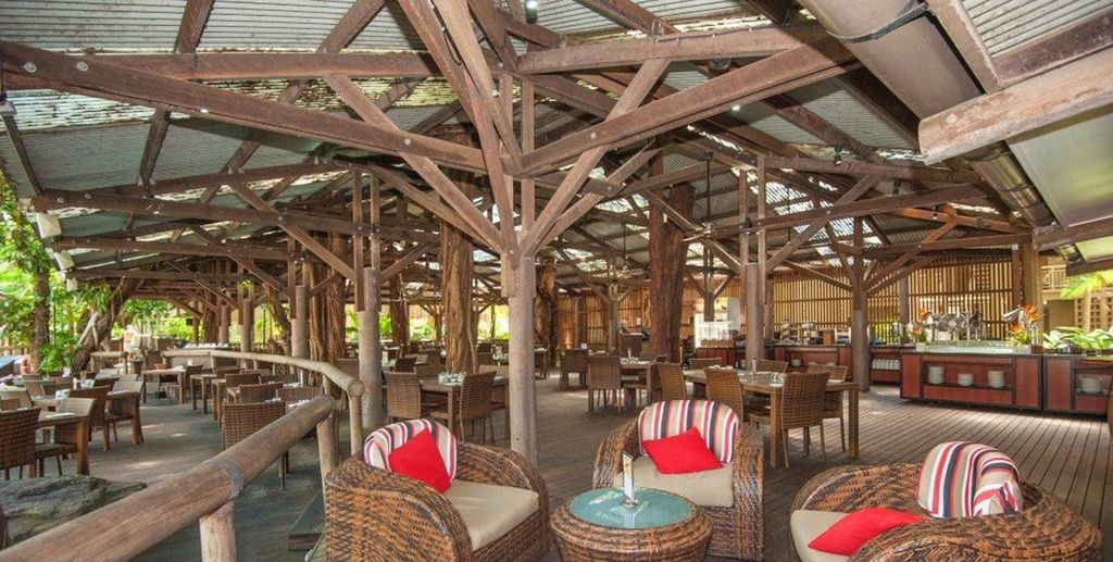 A Tree Bar & Grill with wicker furniture and a wooden deck.
