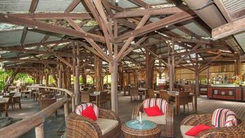 A Tree Bar & Grill with wicker furniture and a wooden deck.