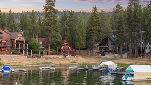 A lakeside property with multiple cabins, docked boats, and a forested backdrop.