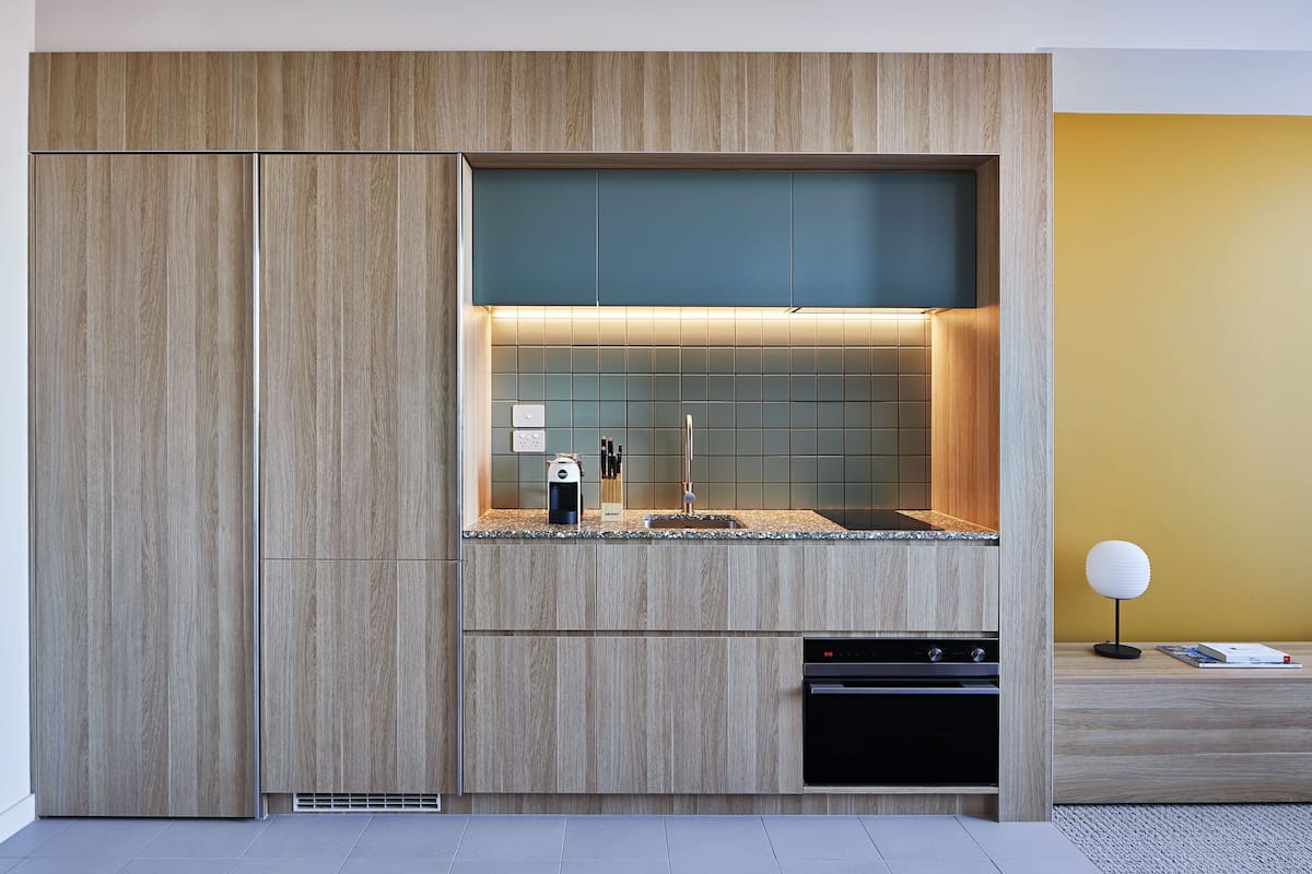 Una cocina moderna con armarios de madera, un lavaplatos empotrado y un lavavajillas.