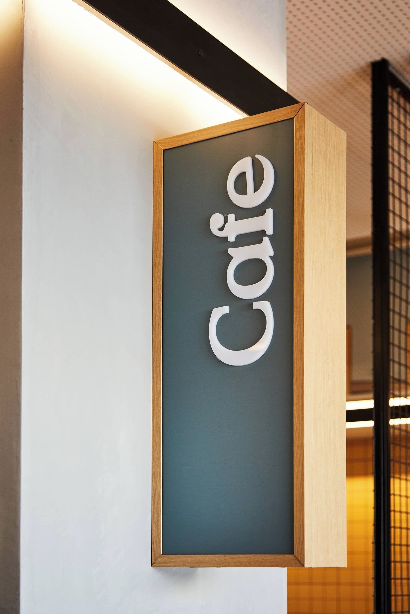 Un letrero con la palabra 'Café' en un diseño moderno y minimalista.