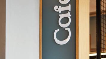 Un letrero con la palabra 'Café' en un diseño moderno y minimalista.