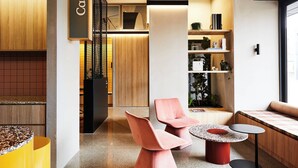 Un café moderne avec un intérieur en bois, un espace salon comprenant un banc et des chaises, et une enseigne indiquant « Café ».