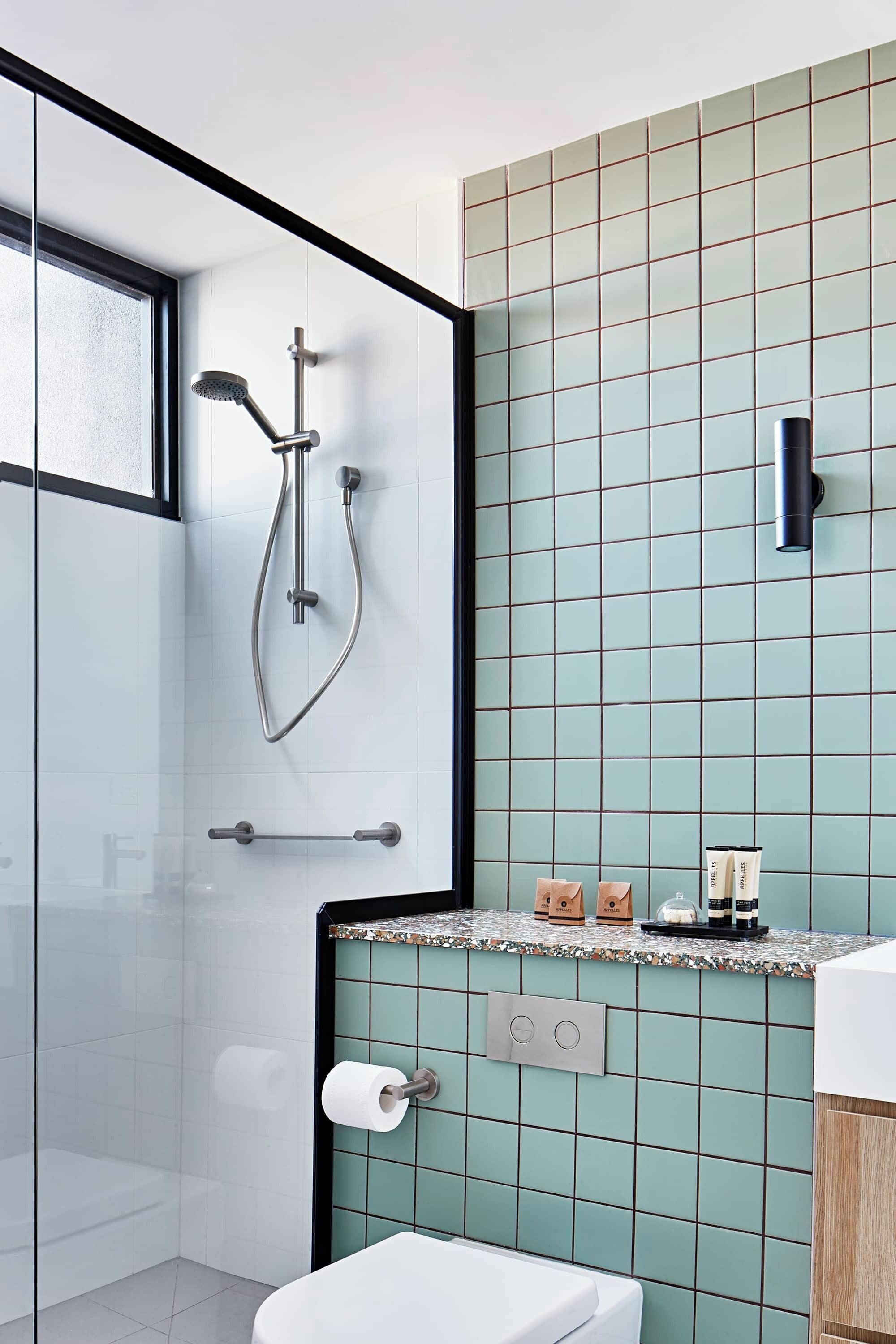 Un baño moderno con cabina de ducha de vidrio, inodoro y lavamanos con encimera.