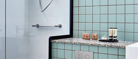 Un baño moderno con cabina de ducha de vidrio, inodoro y lavamanos con encimera.
