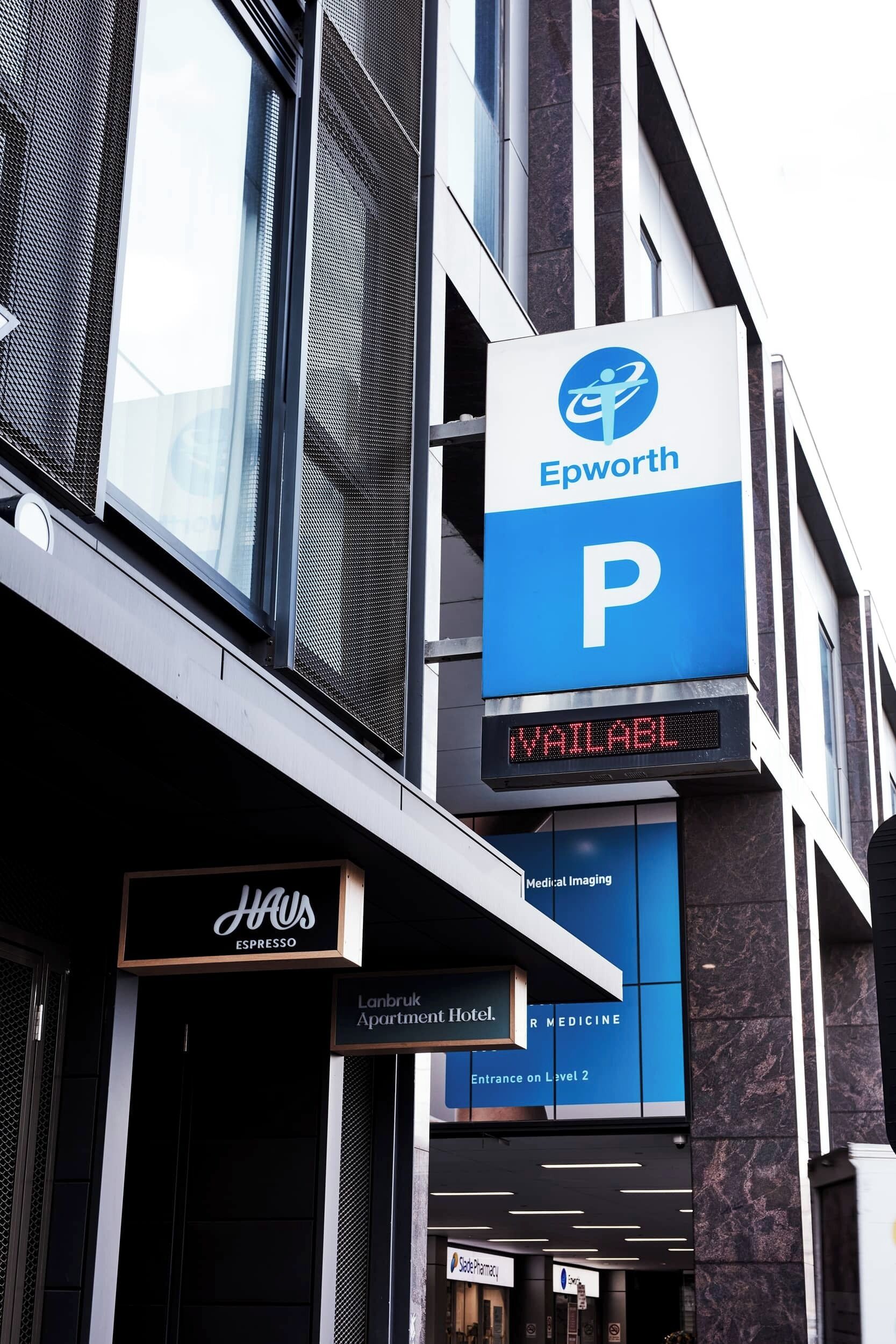 A building with a sign for 'Epworth' and a digital display indicating 'P' for parking.