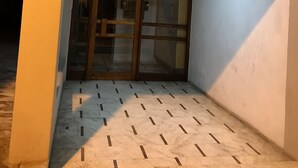 A corner of a building with a tiled floor, a glass door, and a ceiling light. - Luxury flat, close to city center (Zografou Athens)