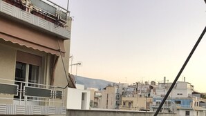 A residential building with multiple balconies, satellite dishes, and a green awning. - Luxury flat, close to city center (Zografou Athens)