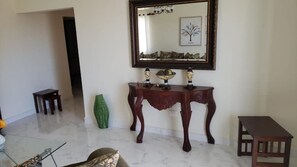 Stylish room with a large mirror, console table, and comfortable chair.