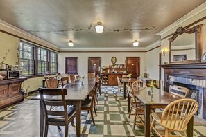 A spacious dining area with a long wooden table, multiple chairs, and a fireplace.