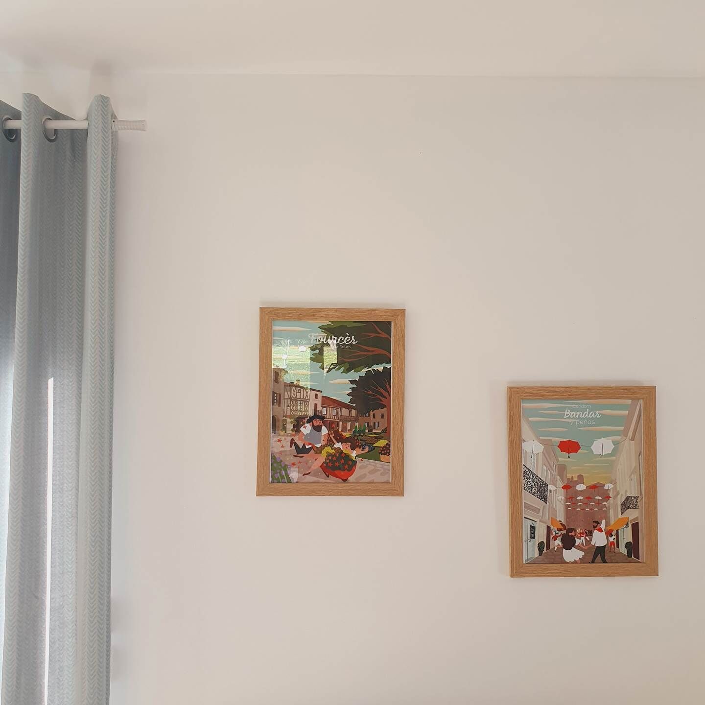 Two framed artworks on a plain wall.