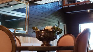 A dining area with a chandelier, wooden chairs, a table, and a decorative bowl. - The Bridge House located in an Beautiful RV Resort near Lake Conroe.  (Montgomery)