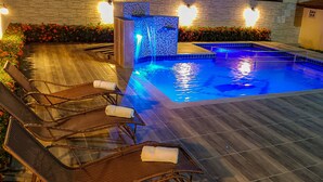 A pool area with lounge chairs and a water feature. - Bem Bahia Hotel (Porto Seguro)