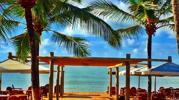 A beachside restaurant with outdoor seating, palm trees, and a view of the ocean. - Bem Bahia Hotel (Porto Seguro)
