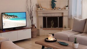 Un soggiorno con televisione, camino e divano.