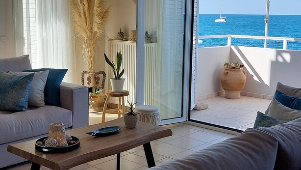 Un soggiorno moderno con un divano, un tavolino da caffè e vista sul mare.