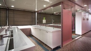 Un bany modern amb un lavabo gran, mirall i armaris.