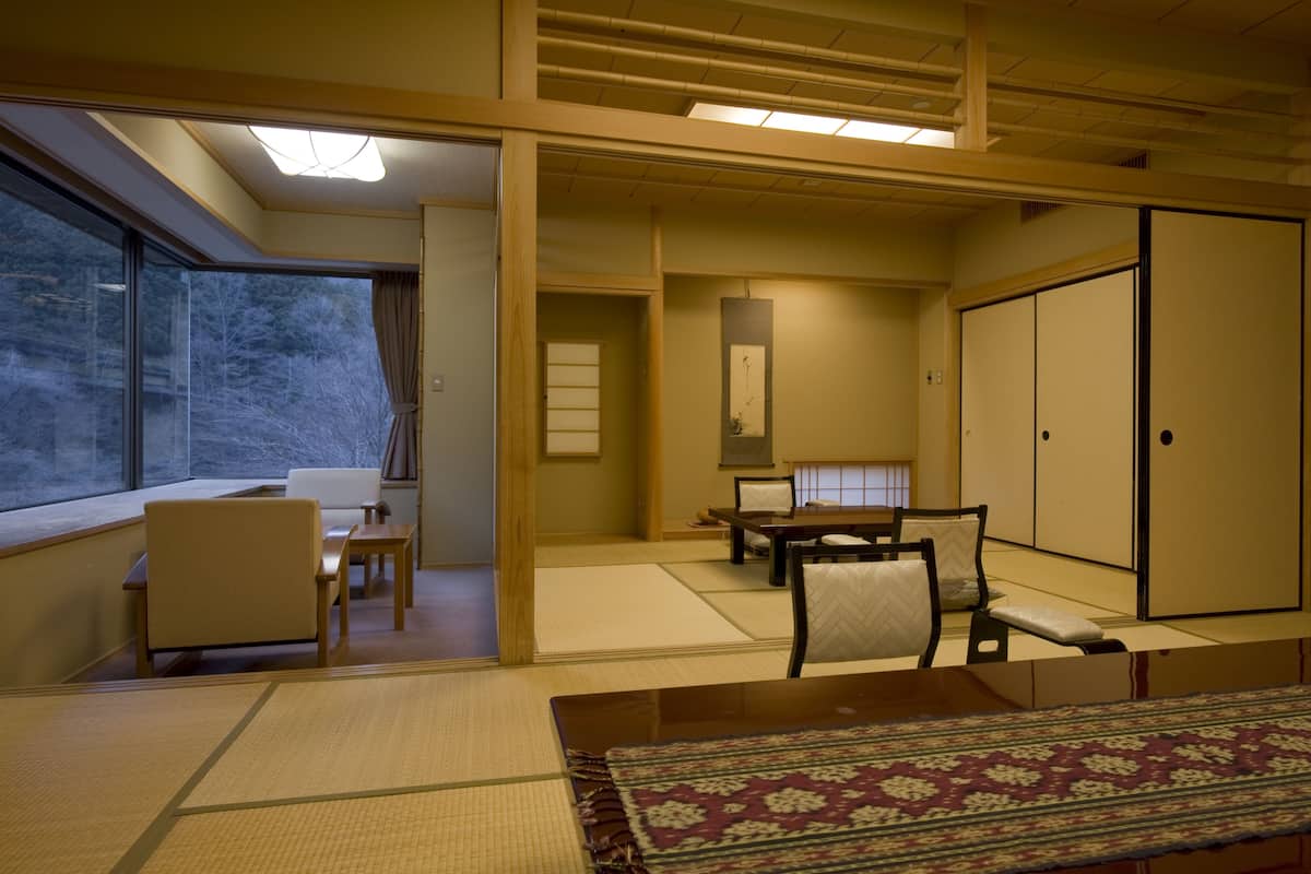 Une pièce de style japonais traditionnel, avec un sol recouvert de tatamis, une table basse et une porte coulissante.