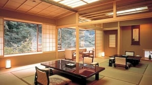 A traditional Japanese room with tatami flooring, a low table, and chairs. - Nishiyama Onsen Keiunkan (Hayakawa)