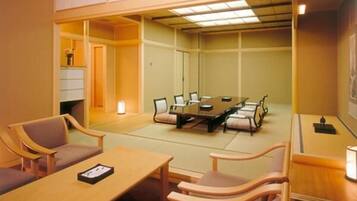 A conference room with a long table, several chairs, and a small side table.